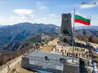 Паметникът на свободата на Шипка по време на честване на Трети март с развято българско знаме и хора.