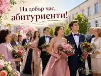 Абитуриенти с цветя пред училище и надпис „На добър час, абитуриенти!“